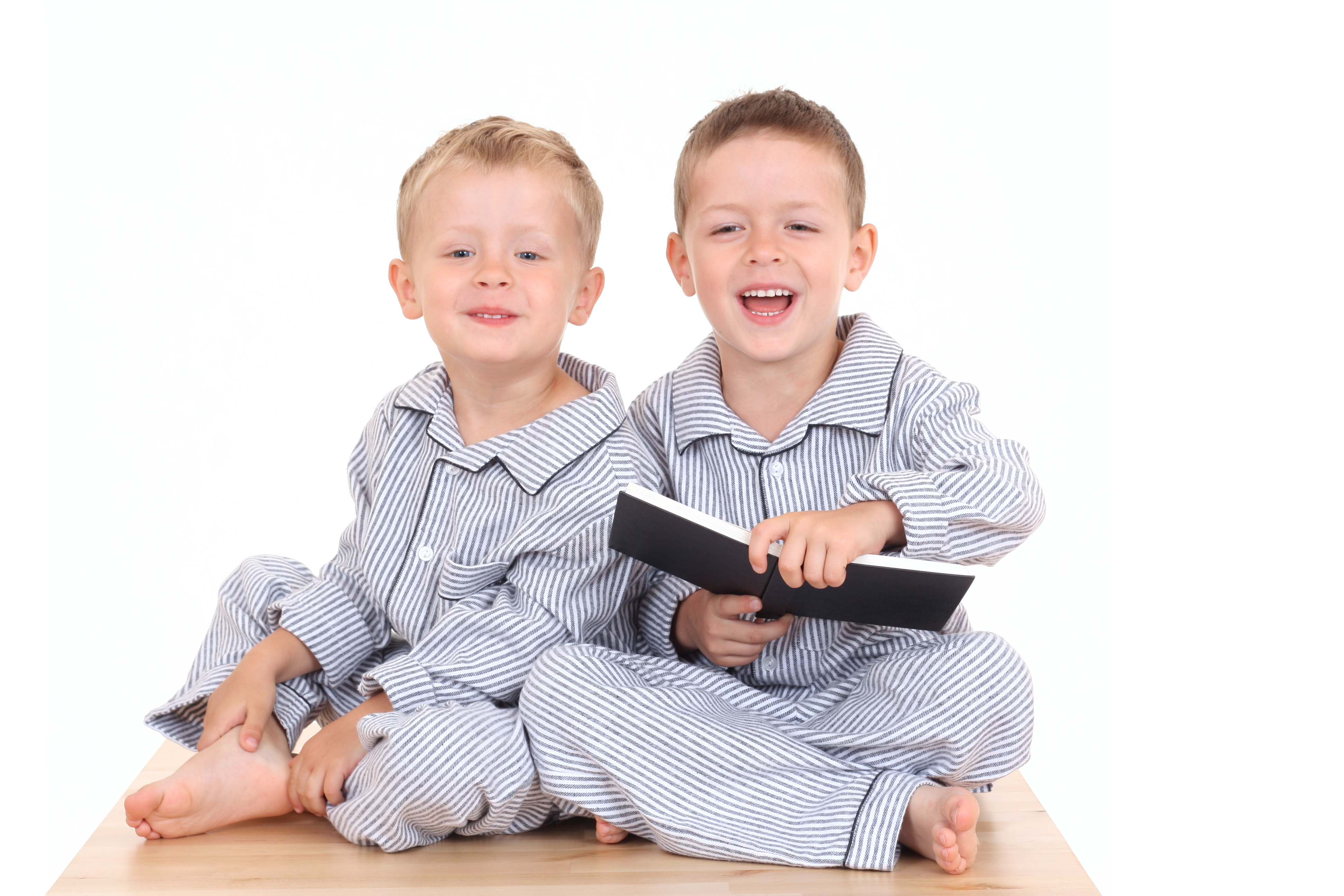 Two boys in pajamas with a book
