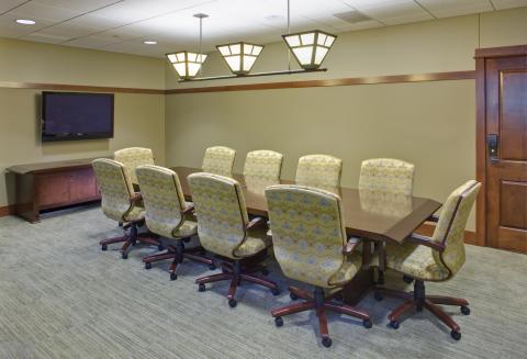 smaller conference room with table, chairs, and TV