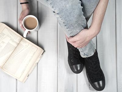 sitting with an open book and mug of coffee