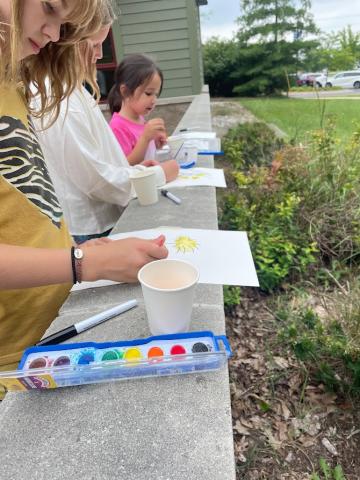 Kids painting pictures on patio