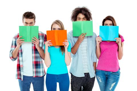 Four teens holding books up to their faces