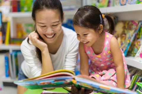 Woman and girl reading a book together