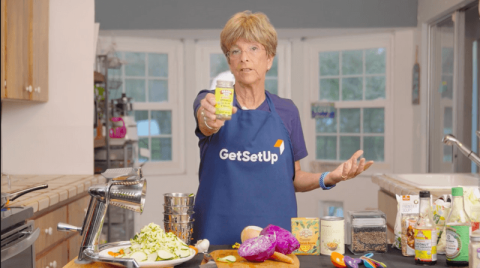 woman in kitchen holding spice jar