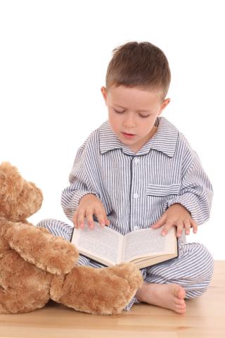 Child reading to a teddy bear