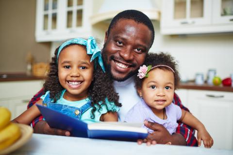 Adult reading a book with two children