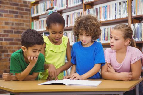 Kids reading a book together