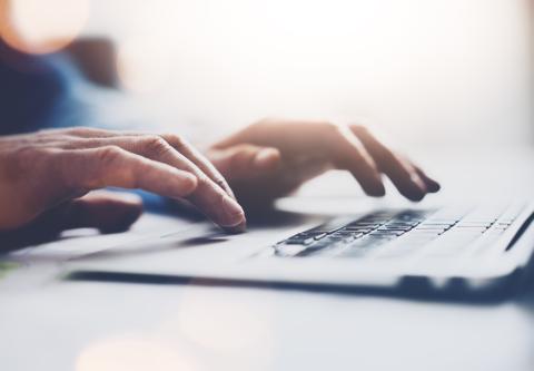 hands typing on a laptop