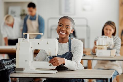 Woman sitting in front of a sewing machine, sewing