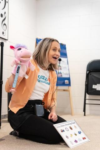 Miss Maggie singing with a puppet
