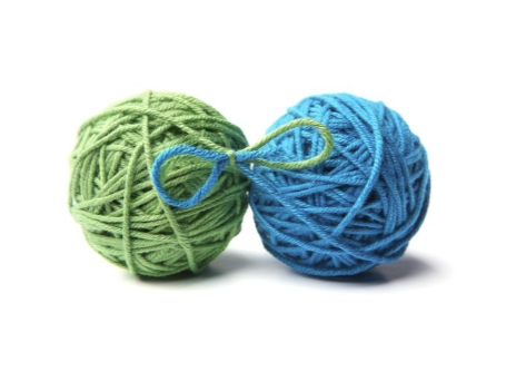 two balls of yarn, each different colors, tied together with a bow.