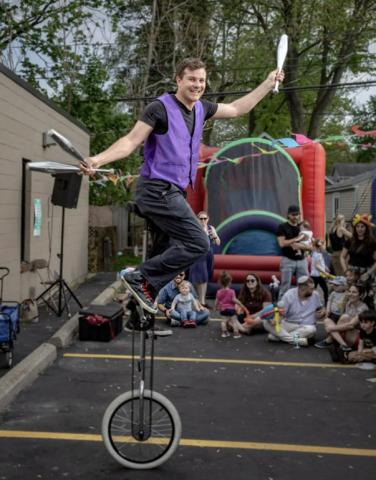 Crazy Craig juggling while on a unicycle