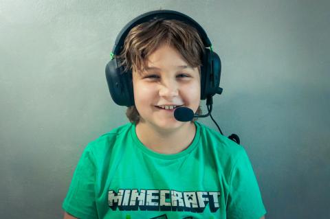 Child with headphones and microphone wearing Minecraft shirt
