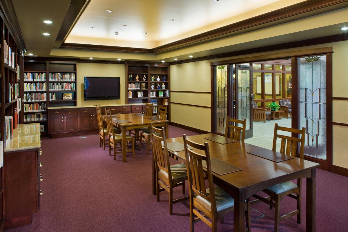 smaller meeting room with tables, chairs, and TV