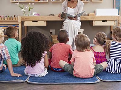 group of kids listening to a story being read to them