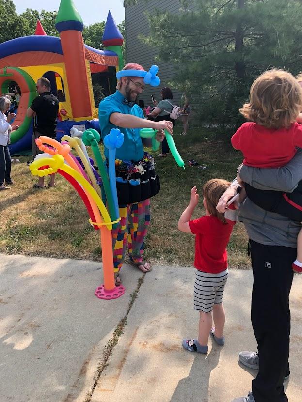 Man twisting a balloon for a family