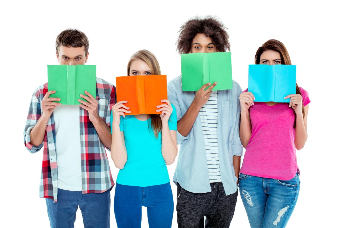 Four teens holding books up to their faces