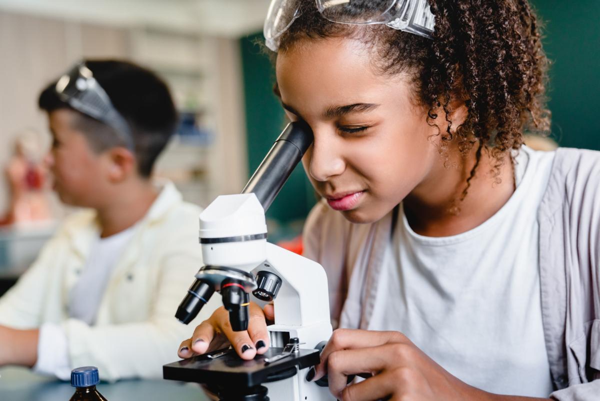 Girl looking through a microscope