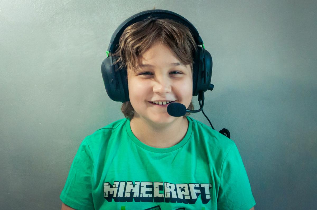 Child with headphones and microphone wearing Minecraft shirt